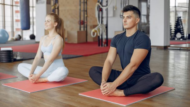 Handsome man in a gym. Sportspeople in a sportswear. Woman training with coach